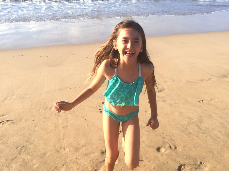 Ailie as a child running on the beach